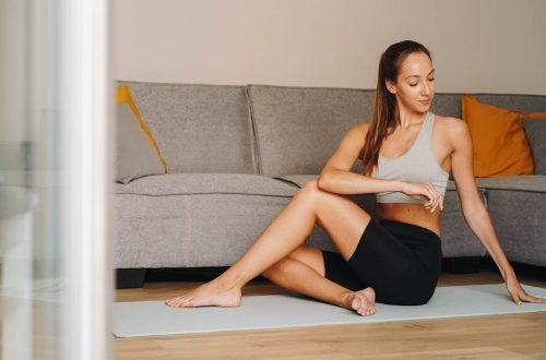 Woman practicing yoga indoors on a mat, embodying fitness and tranquility.