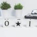 Minimalist desk setup with motivational blocks spelling 'Do It' and small potted plants.